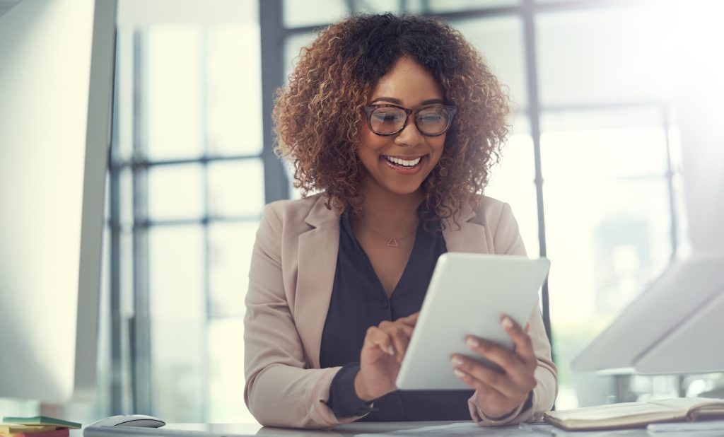 Happy female realtor using tablet in office.