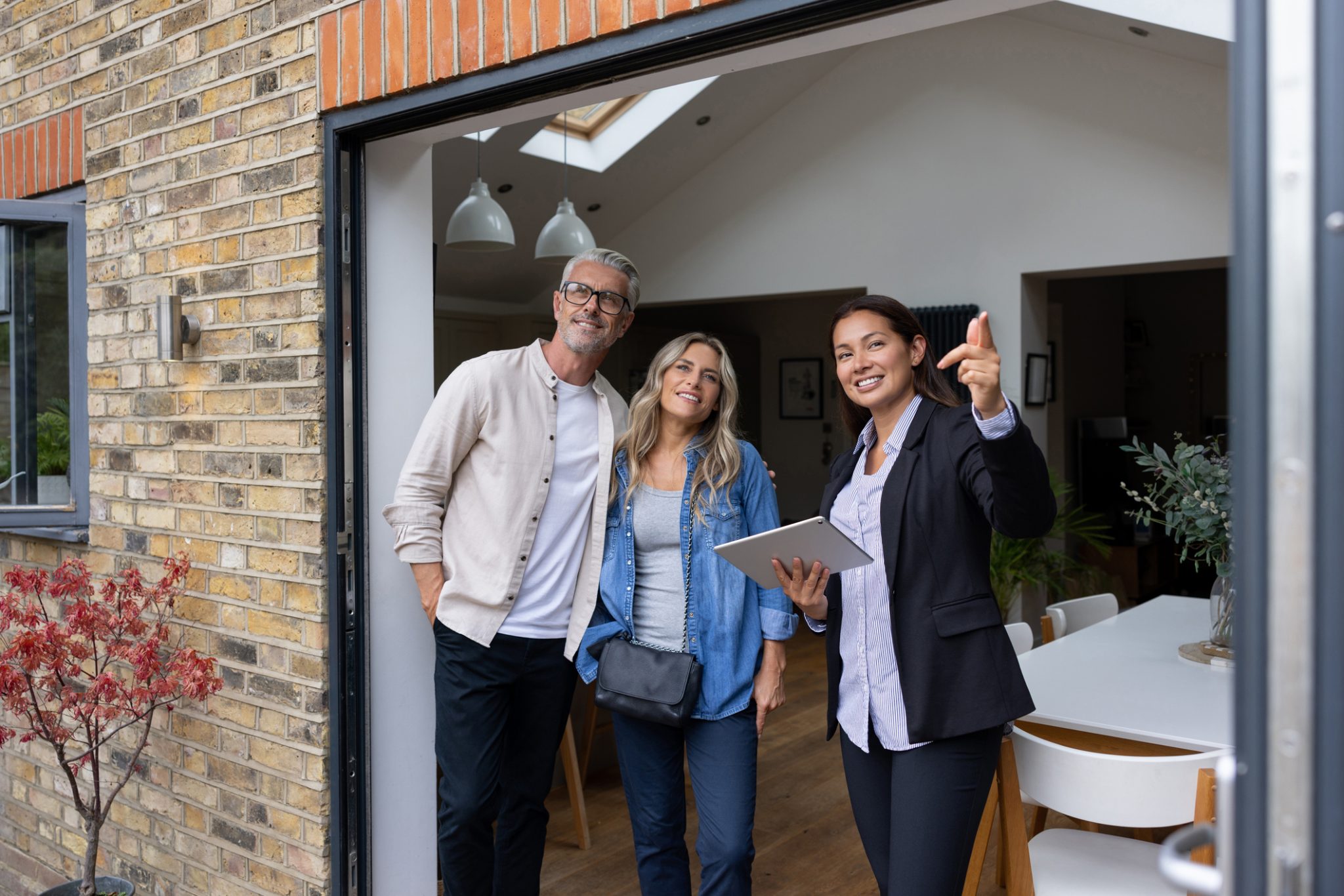 Real estate agent showing a house for sale to a couple