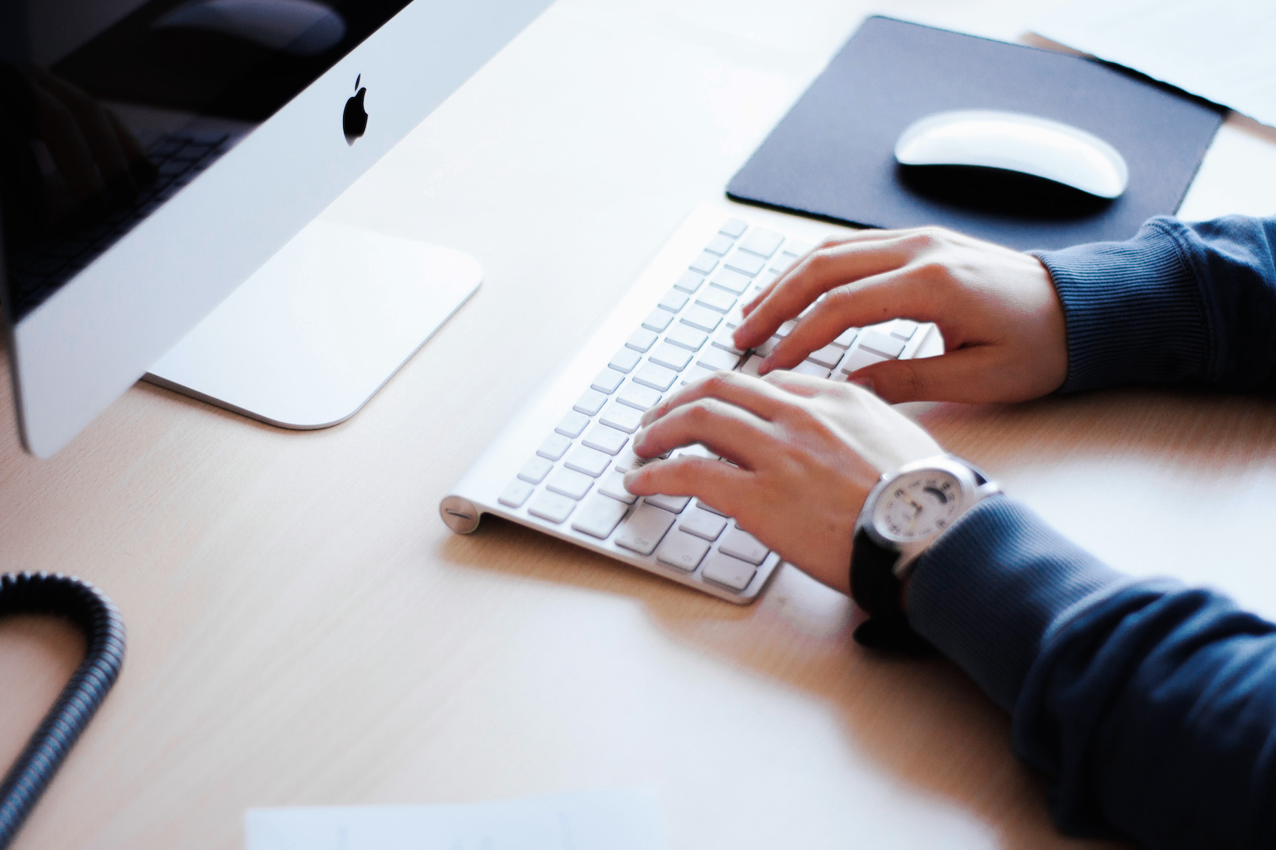 Student typing on computer taking advantage of the online benefits of real estate school