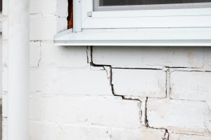 Cracked brick wall of a white house