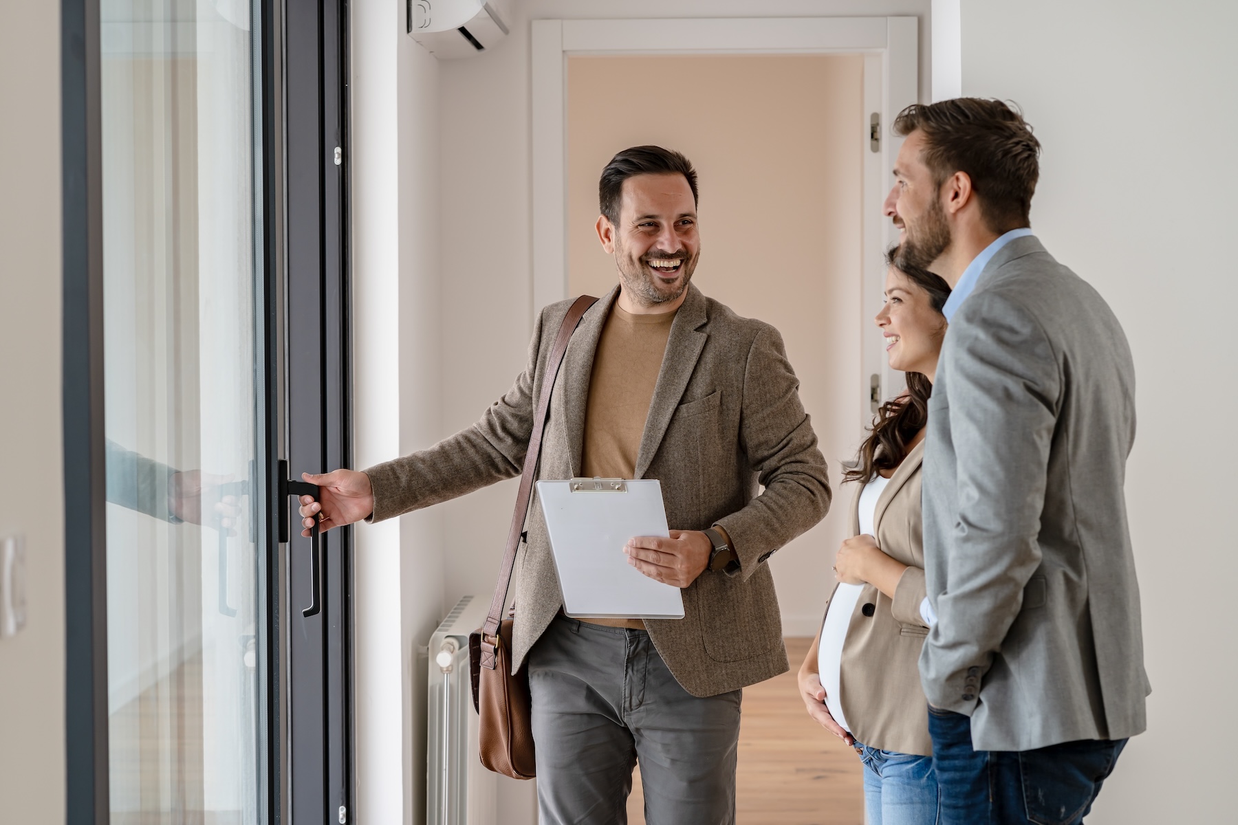 A young couple with a real-estate agent visiting an available apartment