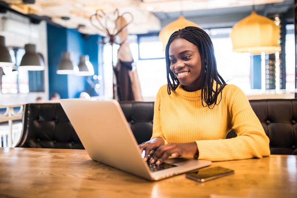 African American female contractor with laptop in a cafe