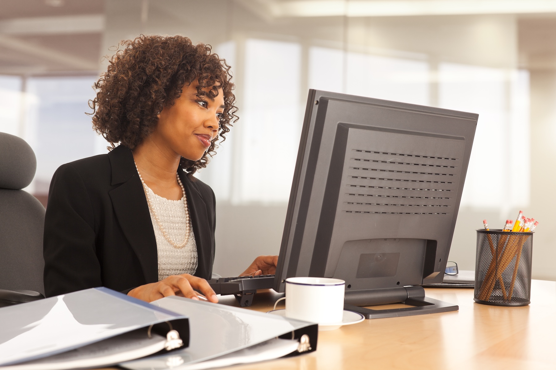 Young businesswoman using computer at desk in an office