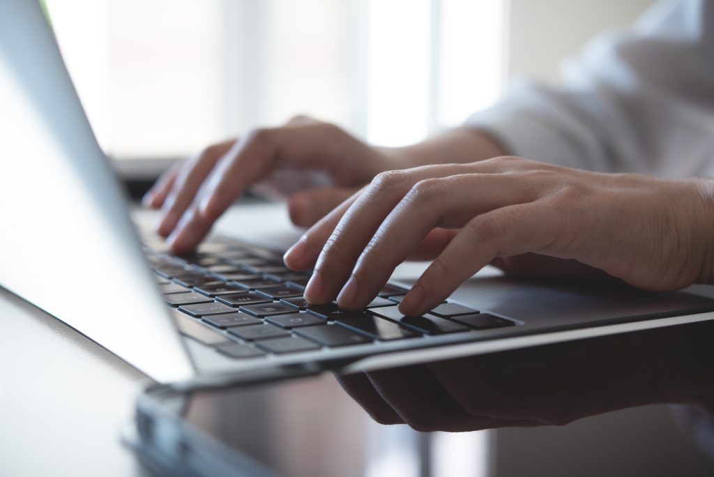Close up of woman's hands typing on laptop computer keyboard
